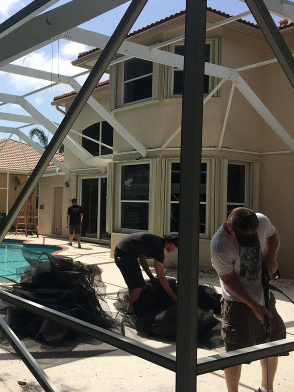 Workers installing white pool enclosure